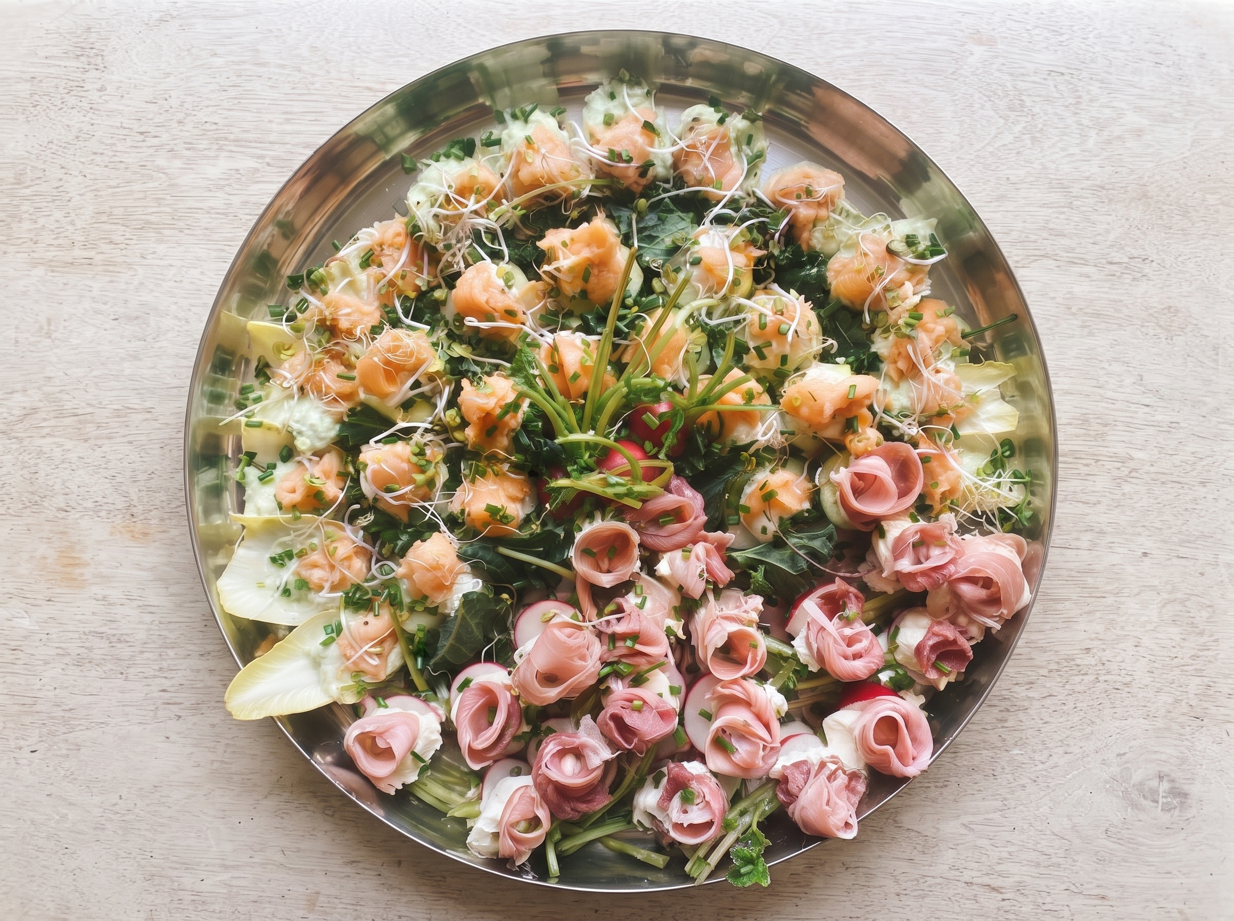 Fuente de salmón, jamón crudo y verdes preparada para evento