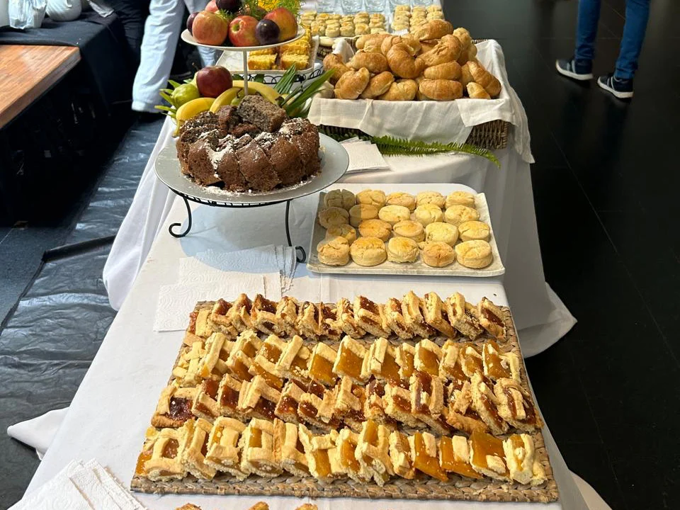 Mesa corporativa larga con sandwiches, tartas y bocados